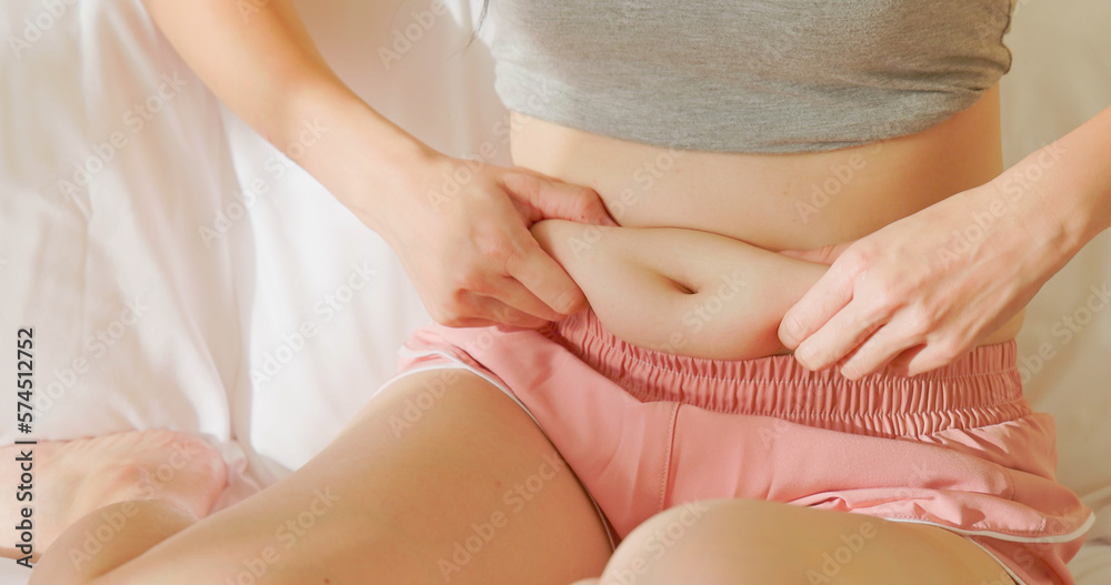 woman pinch excessive fat belly