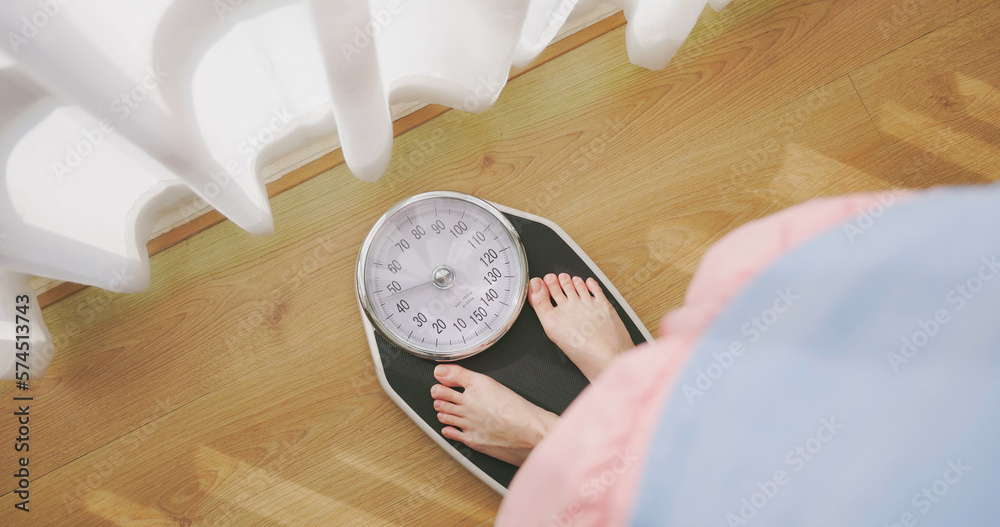 woman measure weight on scale