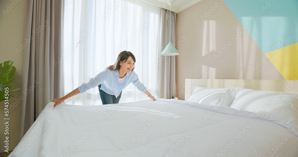 woman changes bed quilt