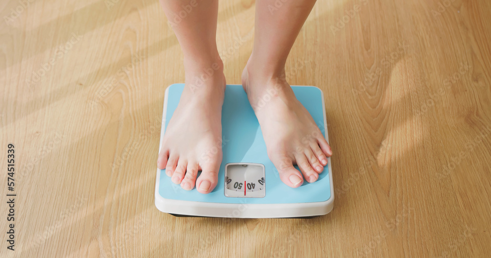 woman measure weight on scale