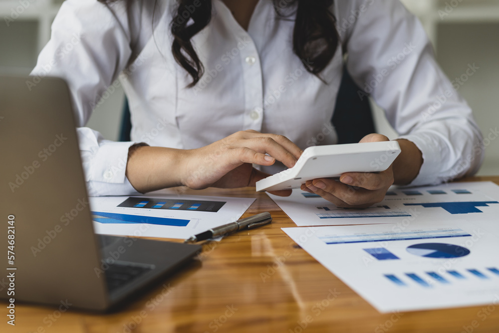 Female business accountants analyze investments, review financial documents and plan budgets.