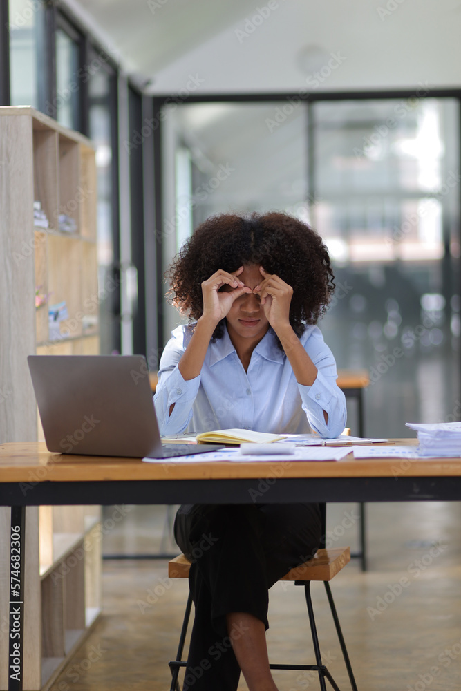 African woman in office stressed and worried about unsuccessfully working on deadlines. Stress and p