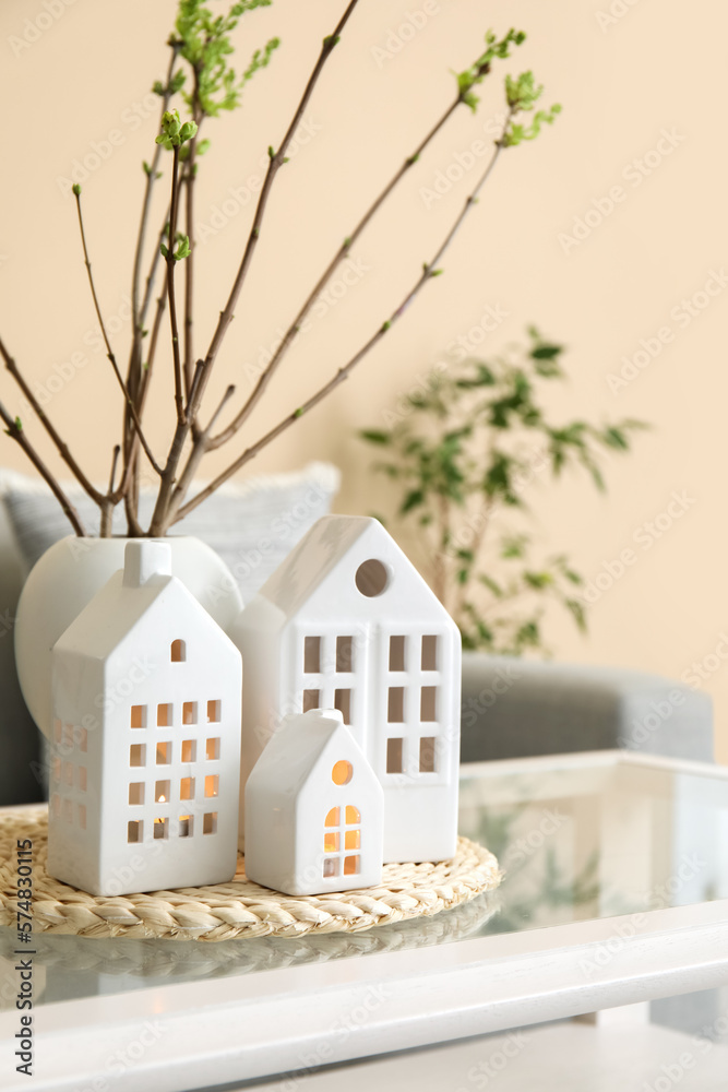 House candle holders and vase with tree branches on table in living room, closeup