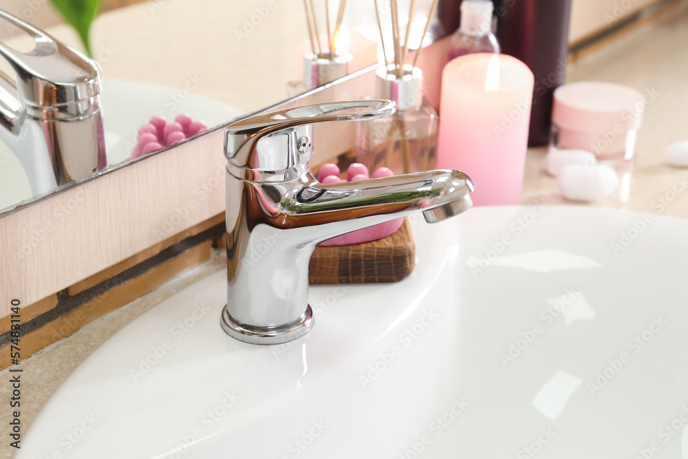 white ceramic sink and bath supplies on table, closeup