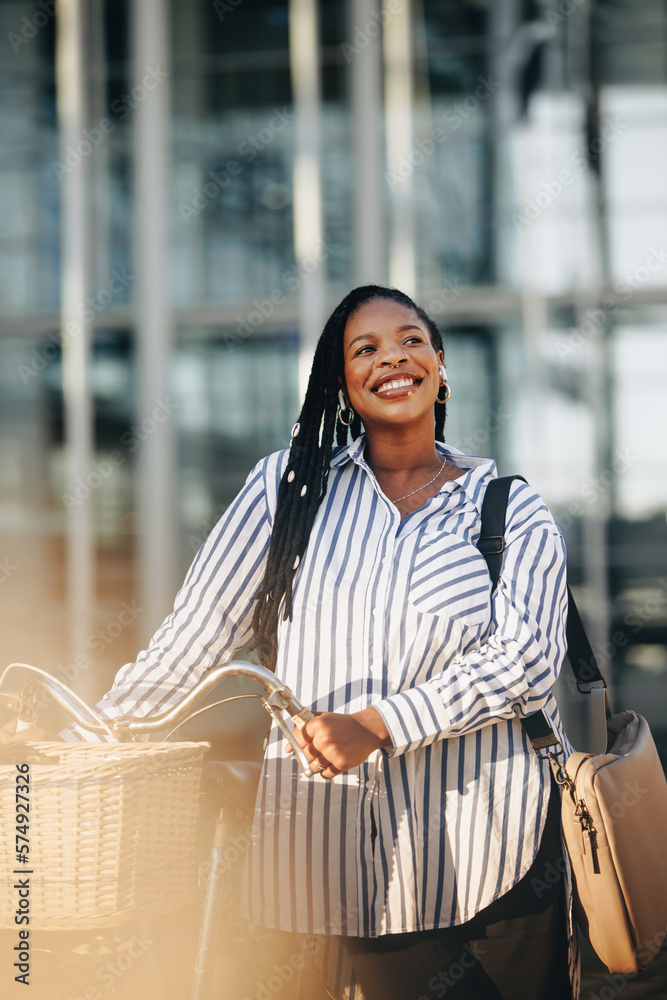 Happy young business woman traveling to work with a bicyle in the city