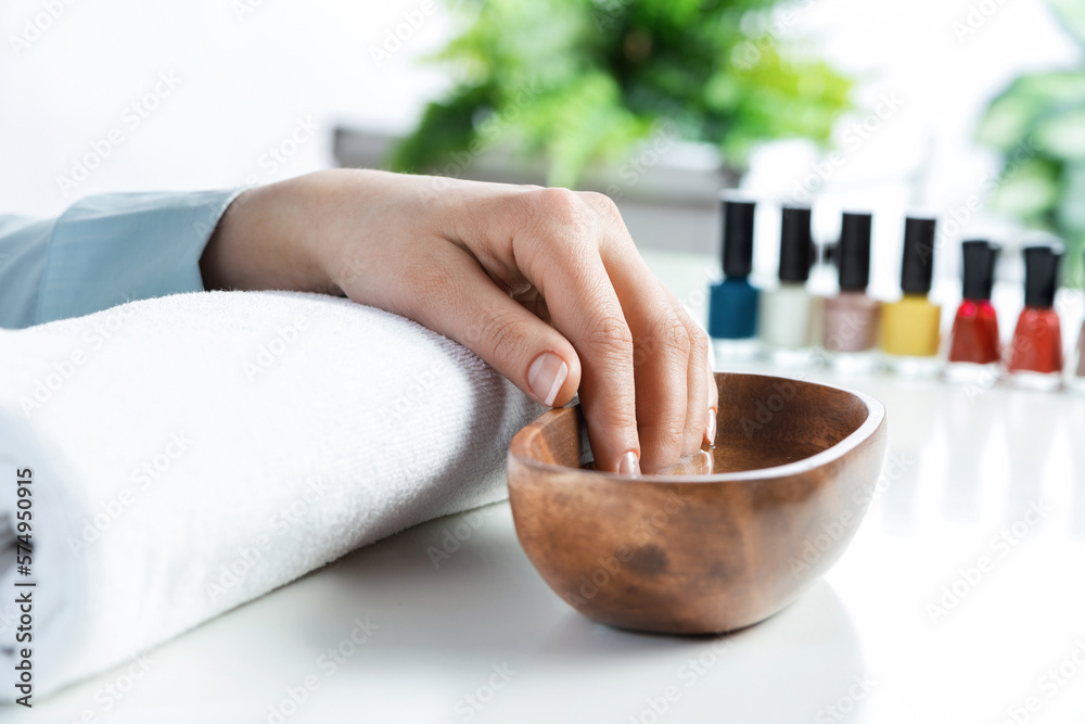 Closeup female hands in wooden bowl with water