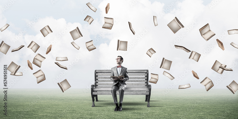 Young businessman or student studying the science and books fly around