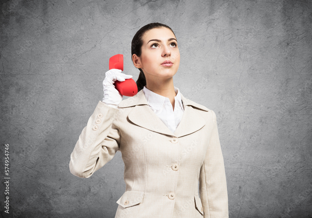 Attractive woman holding vintage red phone