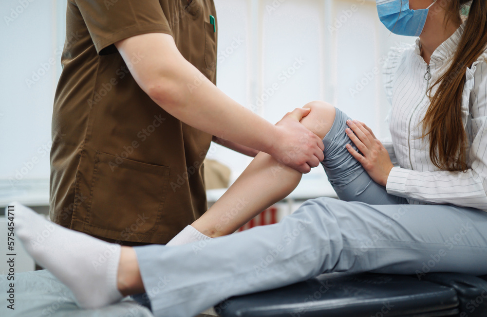 Doctor examining female patient with injured leg. Osteopathy, Chiropractic leg adjustment.