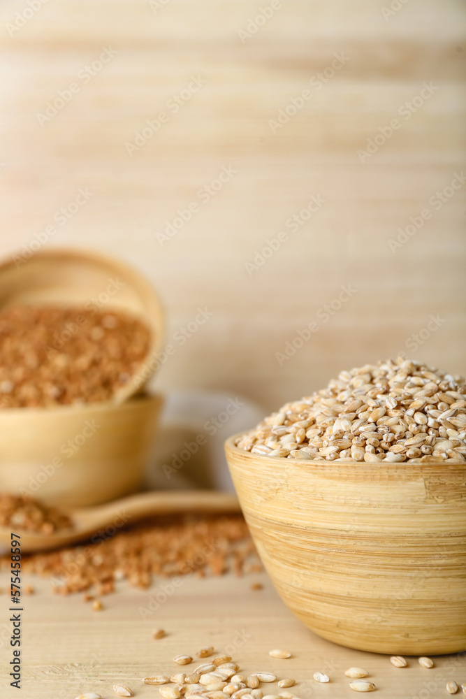 Bowl with pearl barley on wooden background, closeup