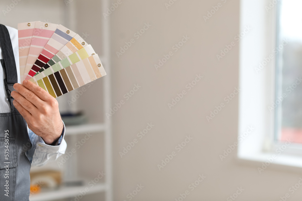 Male painter with color palettes in room, closeup