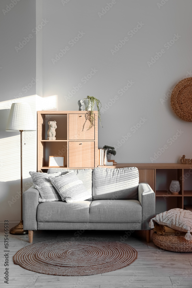 Interior of modern living room with cozy cushions on grey sofa