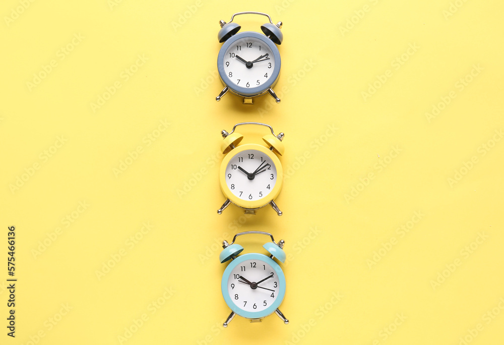 Alarm clocks on yellow background