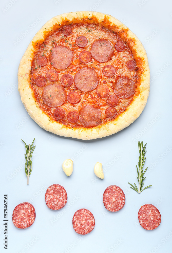 Composition with delicious pepperoni pizza and ingredients on blue background