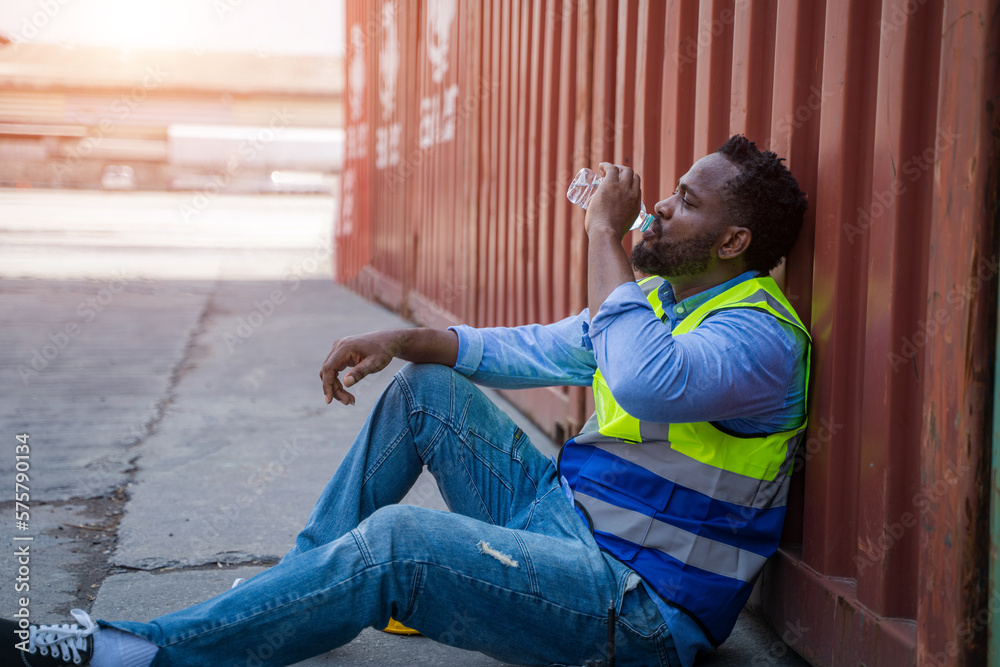 Worker sitting and thinking of something while taking a break after working at container yards.