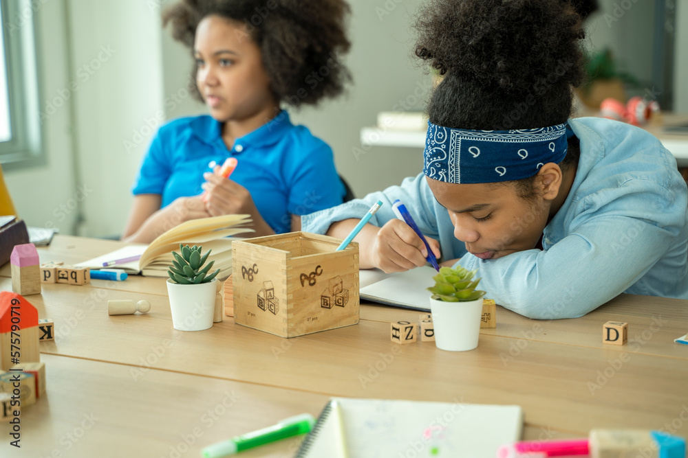 Black girl in classroom with diverse group of children learning new stuff,In elementary school class