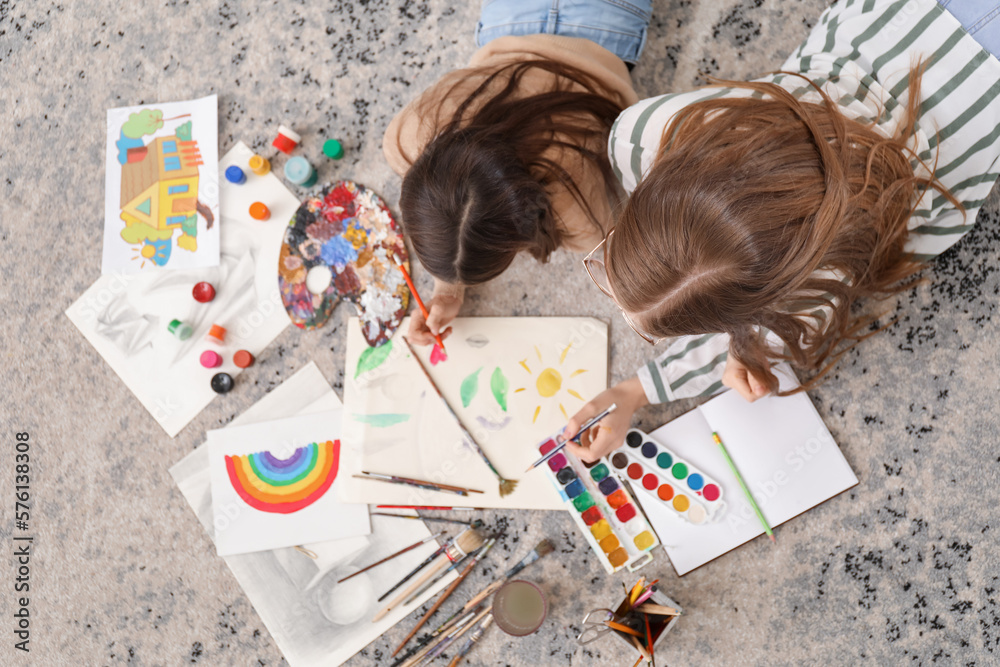 Drawing teacher giving private art lesson to little girl at home, top view