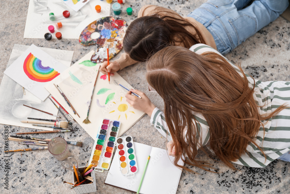 Drawing teacher giving private art lesson to little girl at home, top view