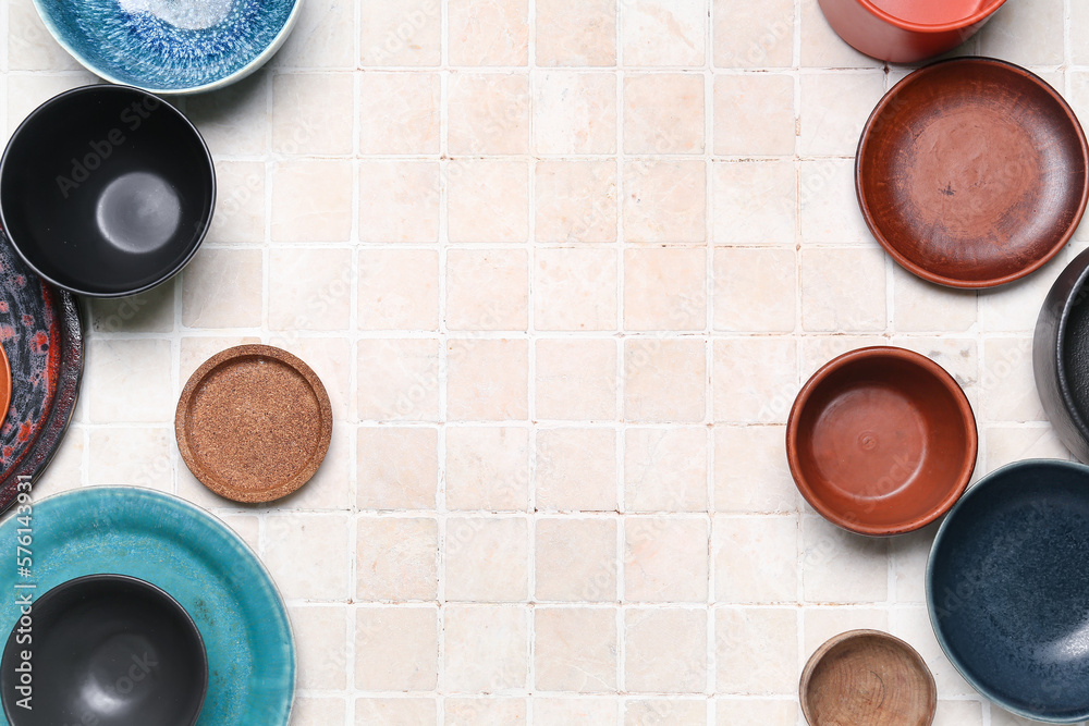 Composition with clean ceramic plates and bowls on tile background