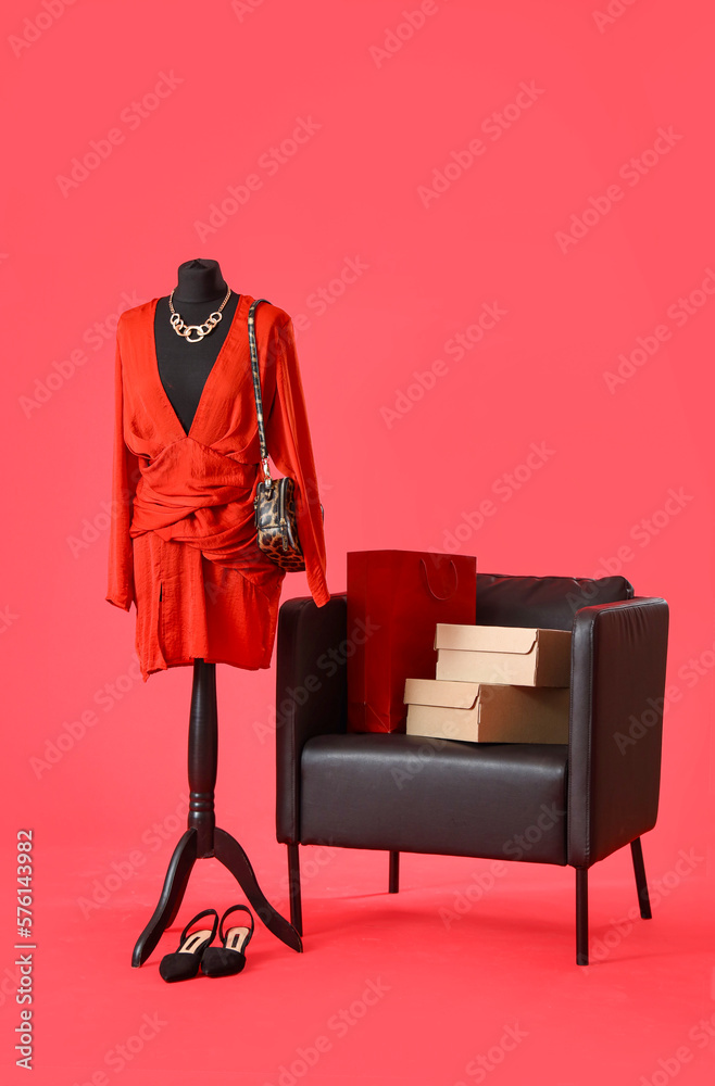 Mannequin with stylish clothes and armchair on red background