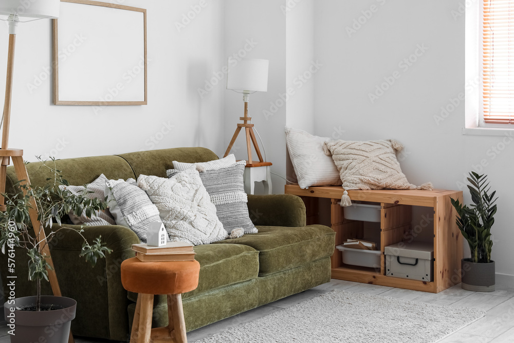 Interior of living room with lamps and cushions on green sofa