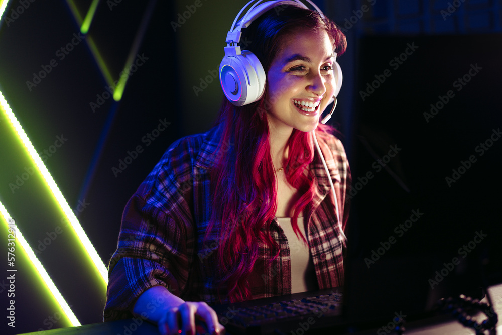 Female gamer smiling at her screen as she dominates a virtual game