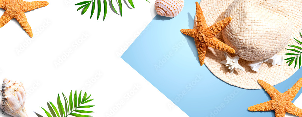 Summer concept with a straw hat and starfish overhead view - flat lay