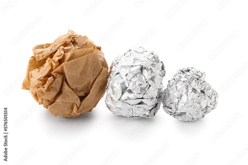 Crumpled balls of aluminium foil and baking paper on white background