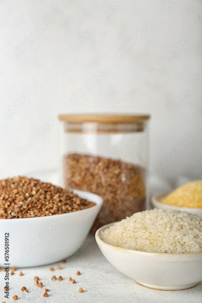 Bowls with cereals on light table, closeup