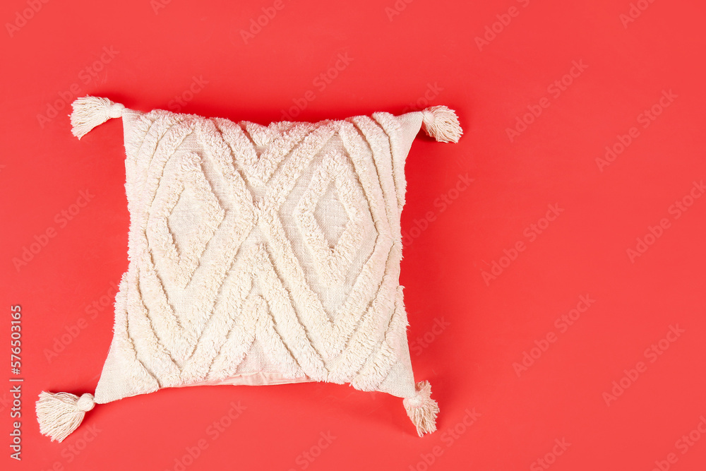 Stylish soft pillow on red background