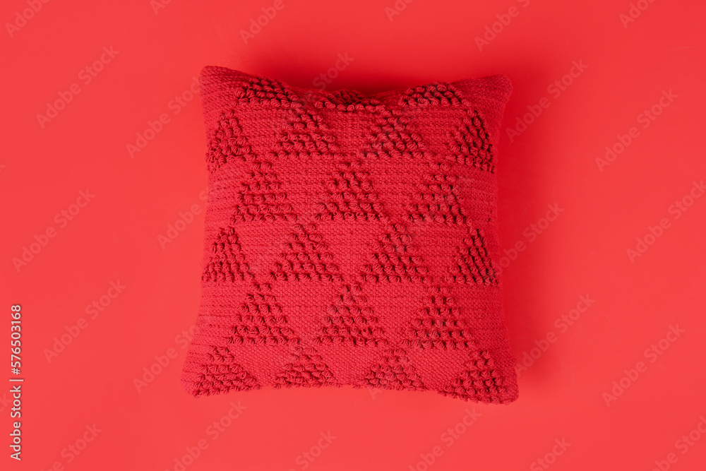 Stylish decorative pillow on red background