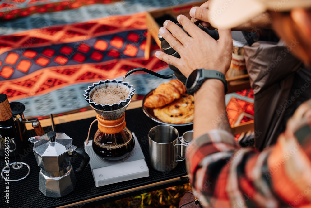 Close up hand of camper drip coffee in the camp, A man pouring water on coffee ground with filter.Dr