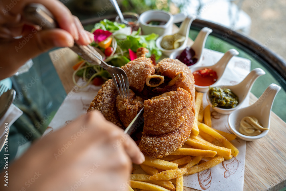 Eisbein with braised cabbage, salad and Yummy french fries with set of souces in bowl. Traditional O