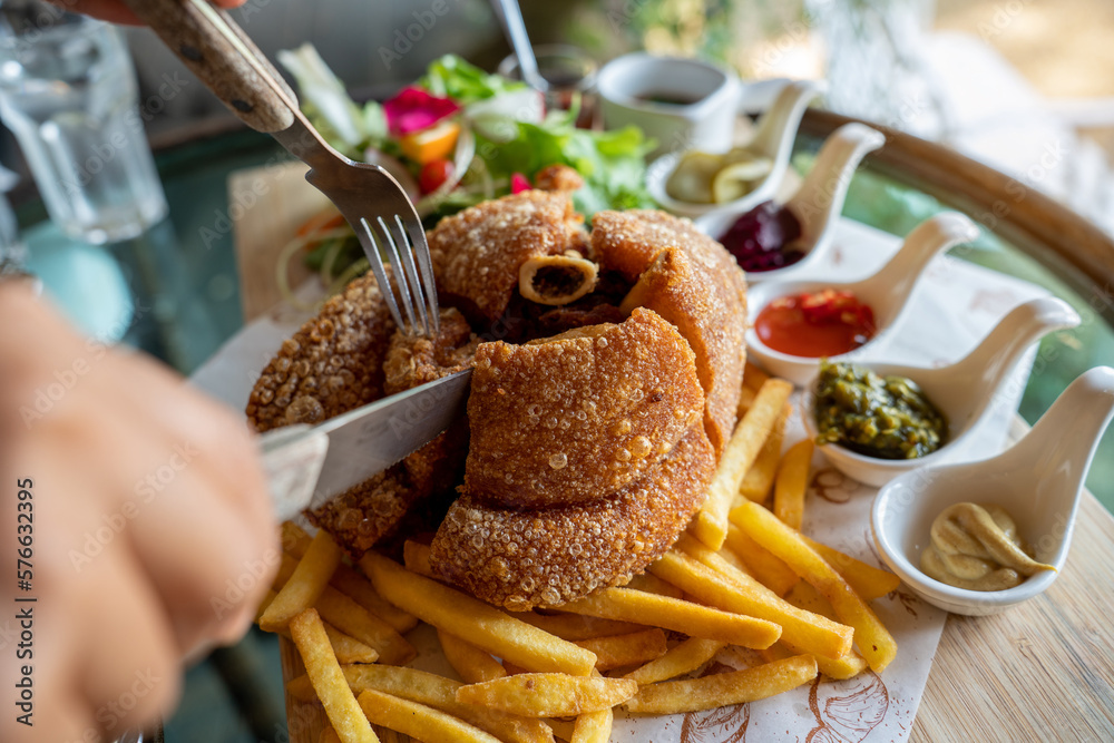 Eisbein with braised cabbage, salad and Yummy french fries with set of souces in bowl. Traditional O