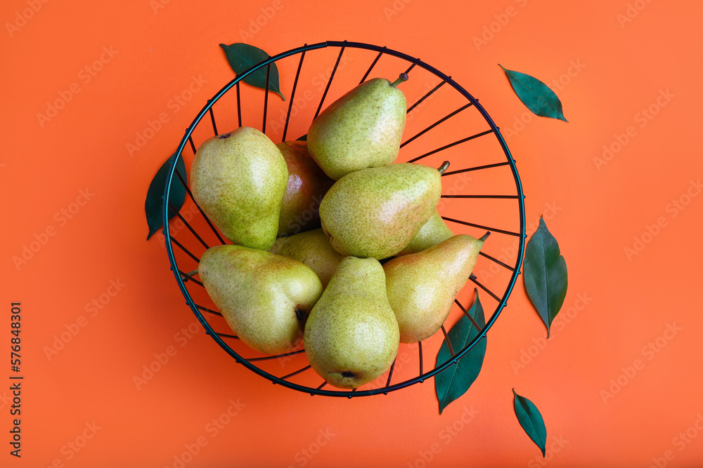 Basket with ripe pears on color background