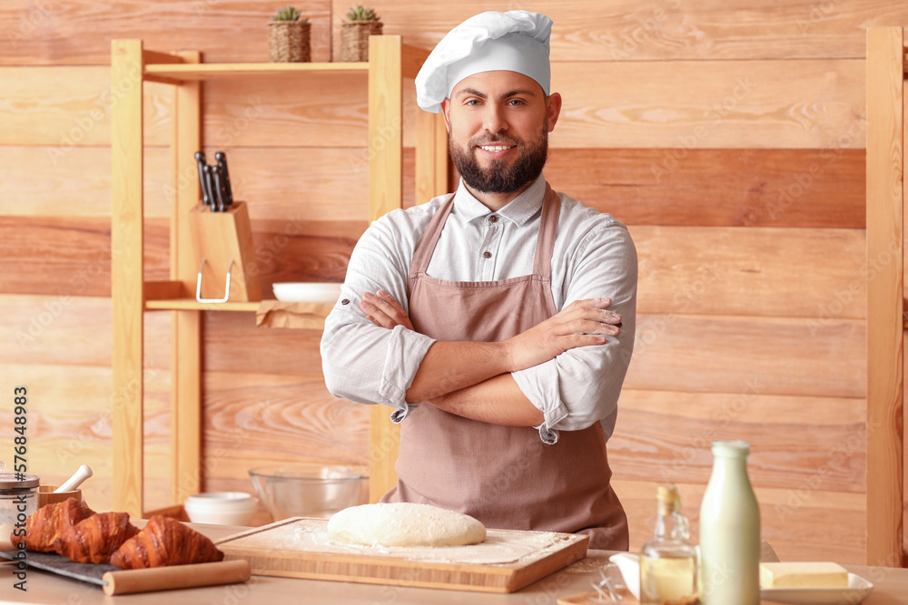 Male baker cooking at table in kitchen