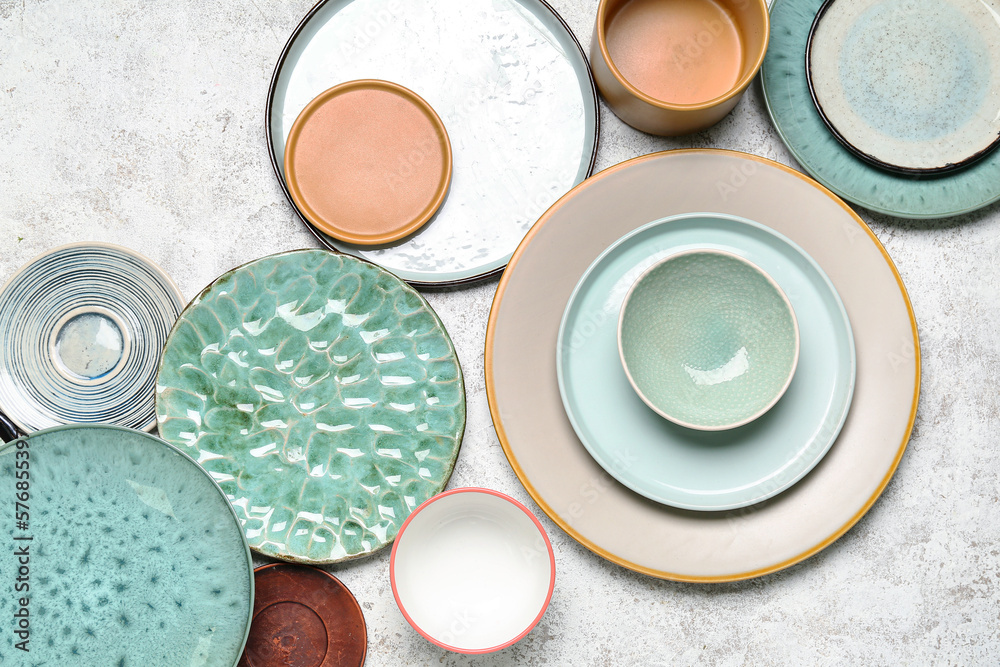 Composition with clean ceramic plates and bowls on white background