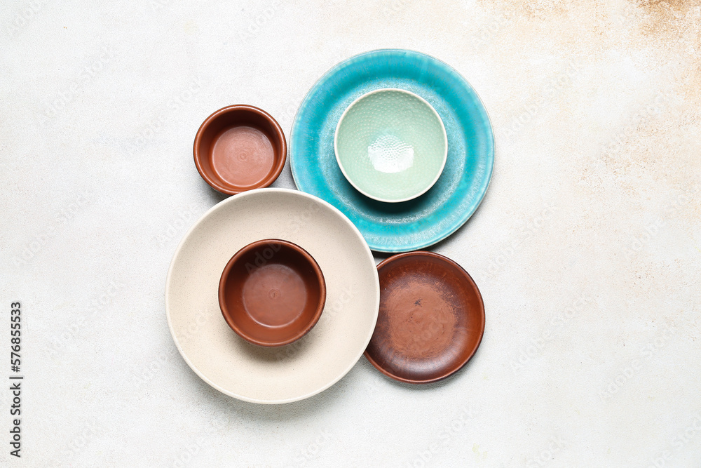 Composition with clean ceramic plates and bowls on white background