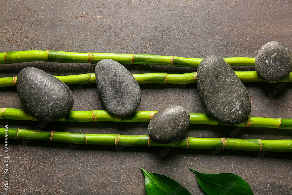 Spa stones and bamboo on dark background, top view