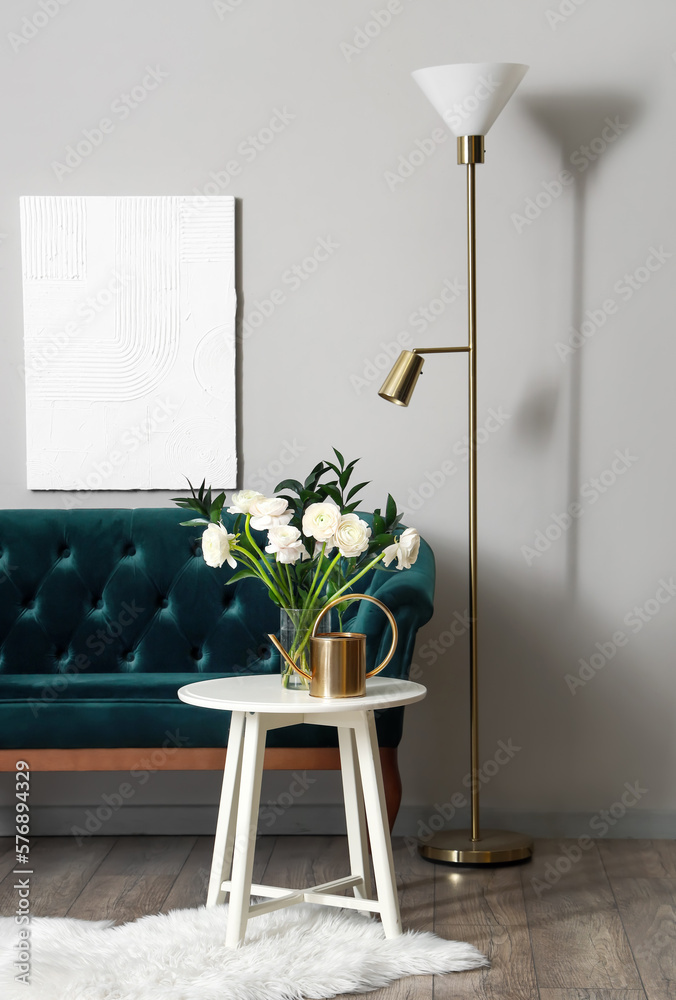 Vase with ranunculus flowers on table in interior of living room