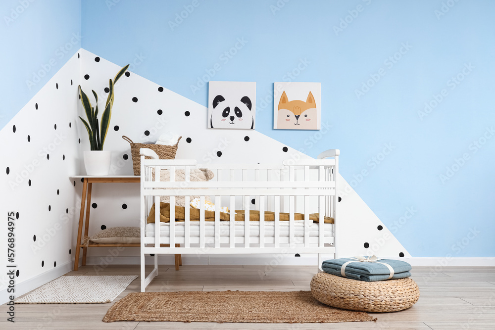 Interior of childrens bedroom with crib and pictures