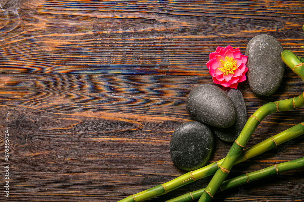 Spa stones and bamboo on wooden background, top view