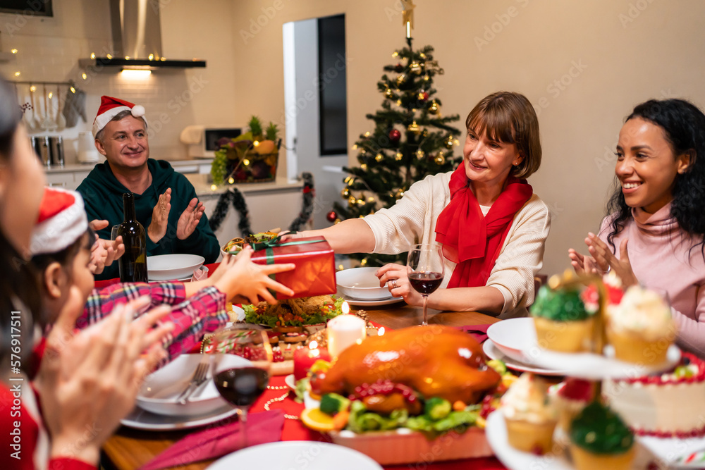 Multi-ethnic big family celebrating Christmas party together in house. 