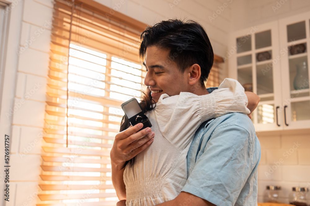 Asian romantic man making surprise proposal of marriage to girlfriend. 