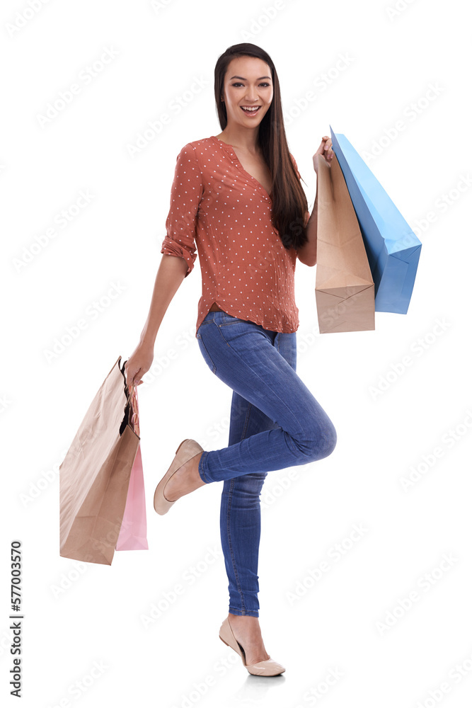 A petite trendy, happy fashionable female model or customer standing on one leg with a shopping bag 