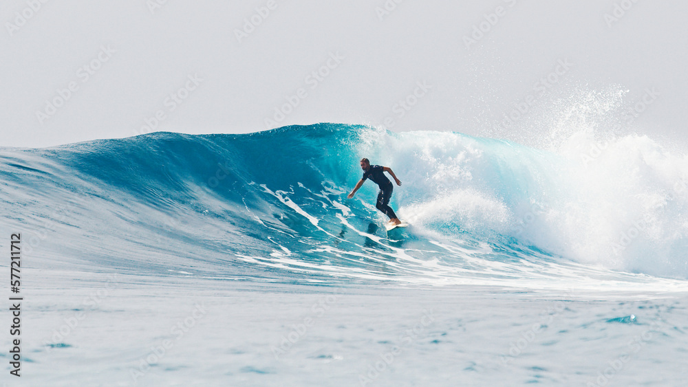 Surfer rides the wave during day