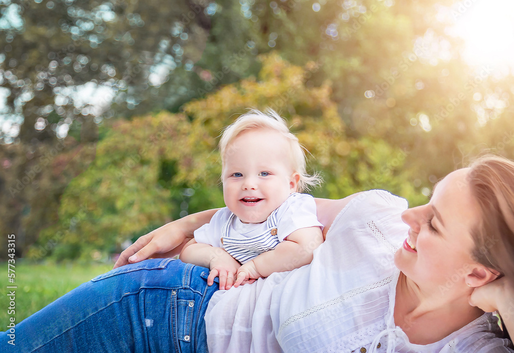 Healthy child (kid) having fun with mother in the sunny summer day at the park. Caucasians happy bab