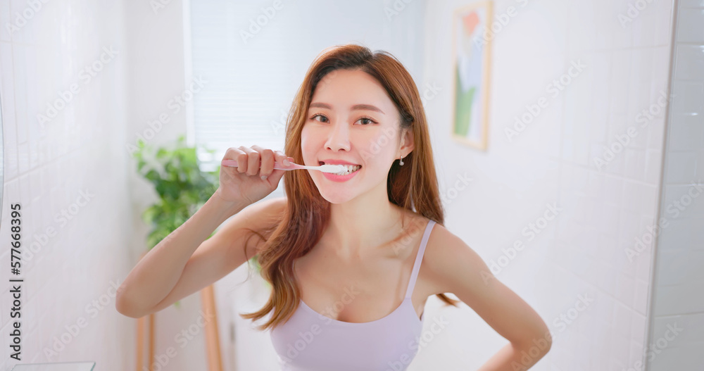 asian smiling woman brush teeth