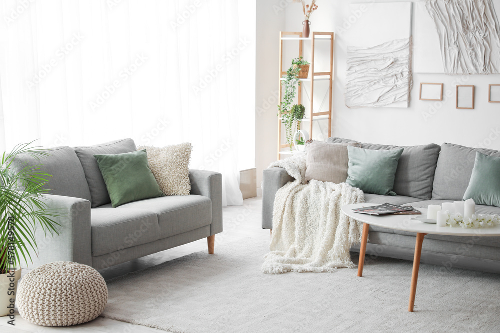 Interior of modern living room with sofas, table and creative artwork