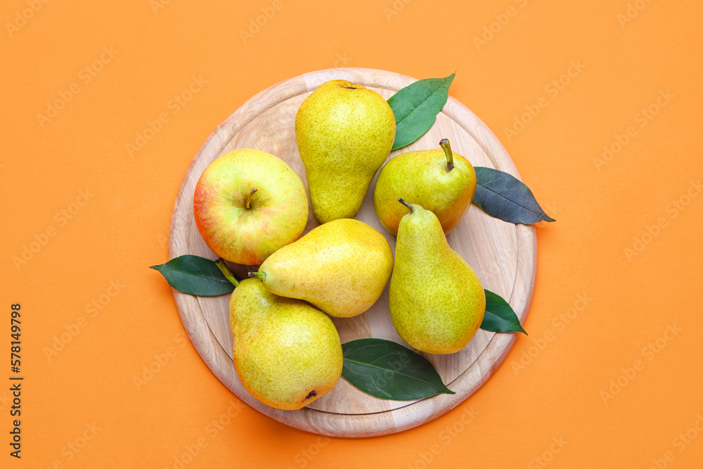 Wooden board with fresh pears on color background